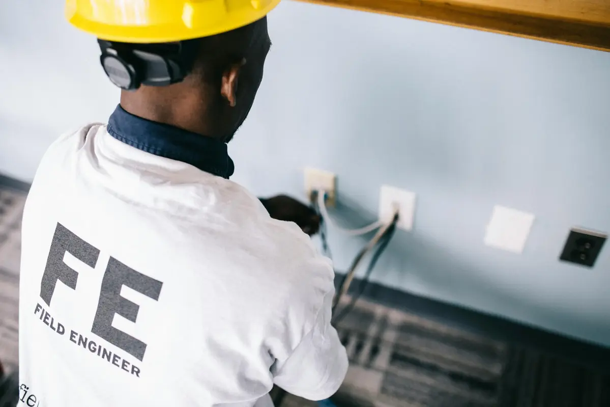 Un électricien en train d'intervenir sur une prise électrique